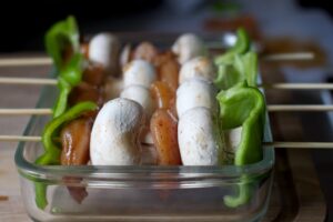Healthy meal prep with chicken and vegetable skewers in a glass container