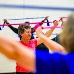 Senior woman exercising with a resistance band in a fitness class
