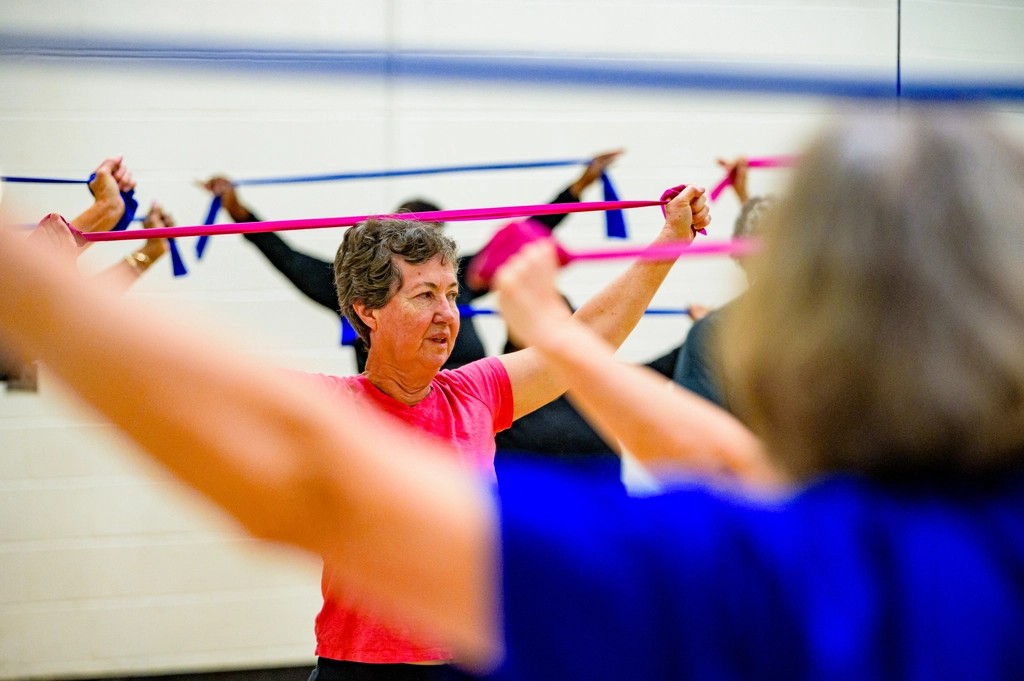 Senior woman exercising with a resistance band in a fitness class